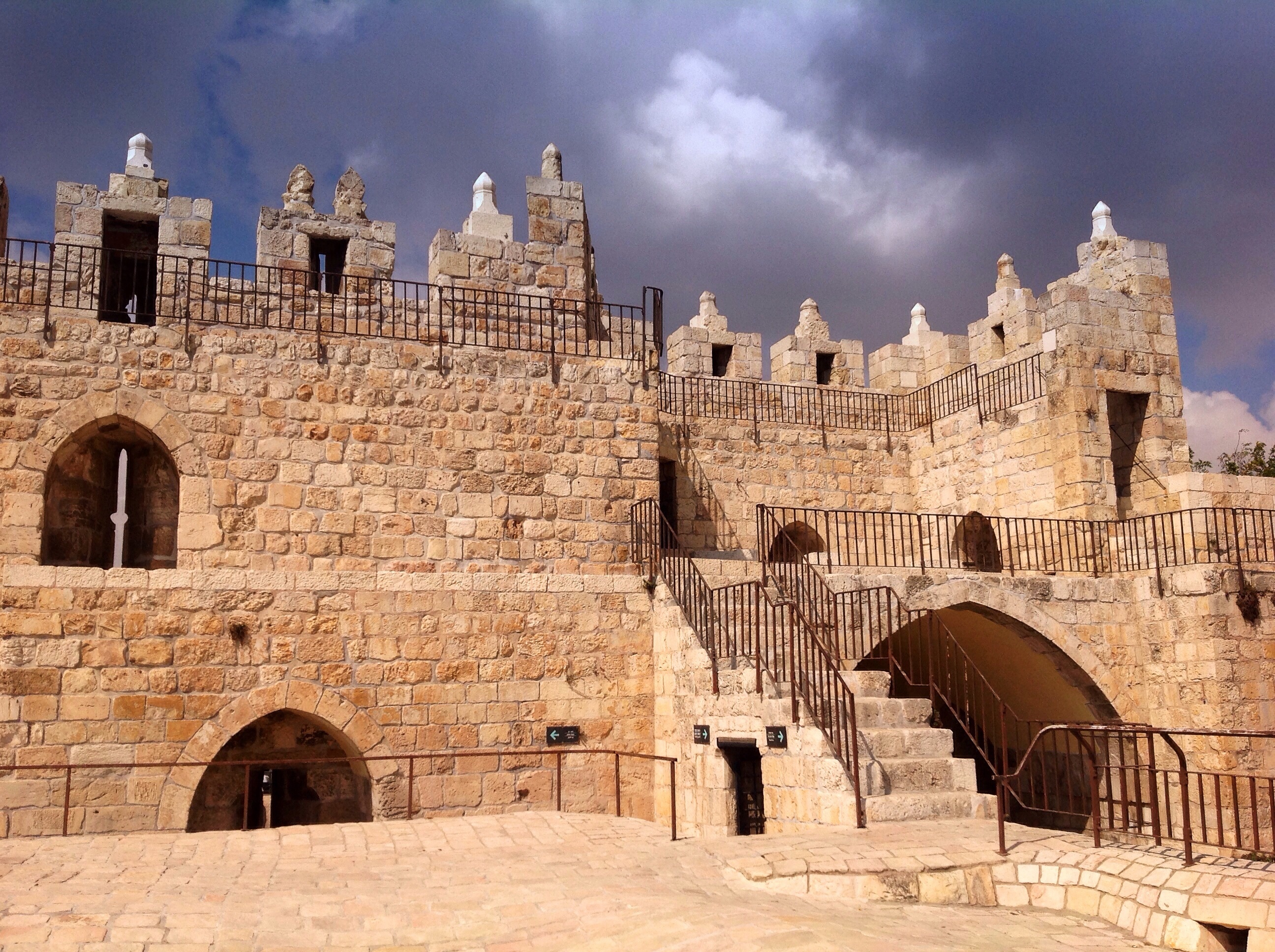 A professional color photograph of the old walls of the Damascus Gate in Jerusalem.