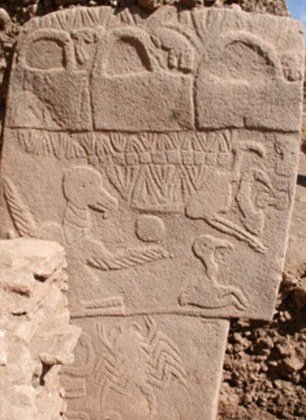 A photo of a Gobekli stone carving with pictures of figures and animals carved into the stone.